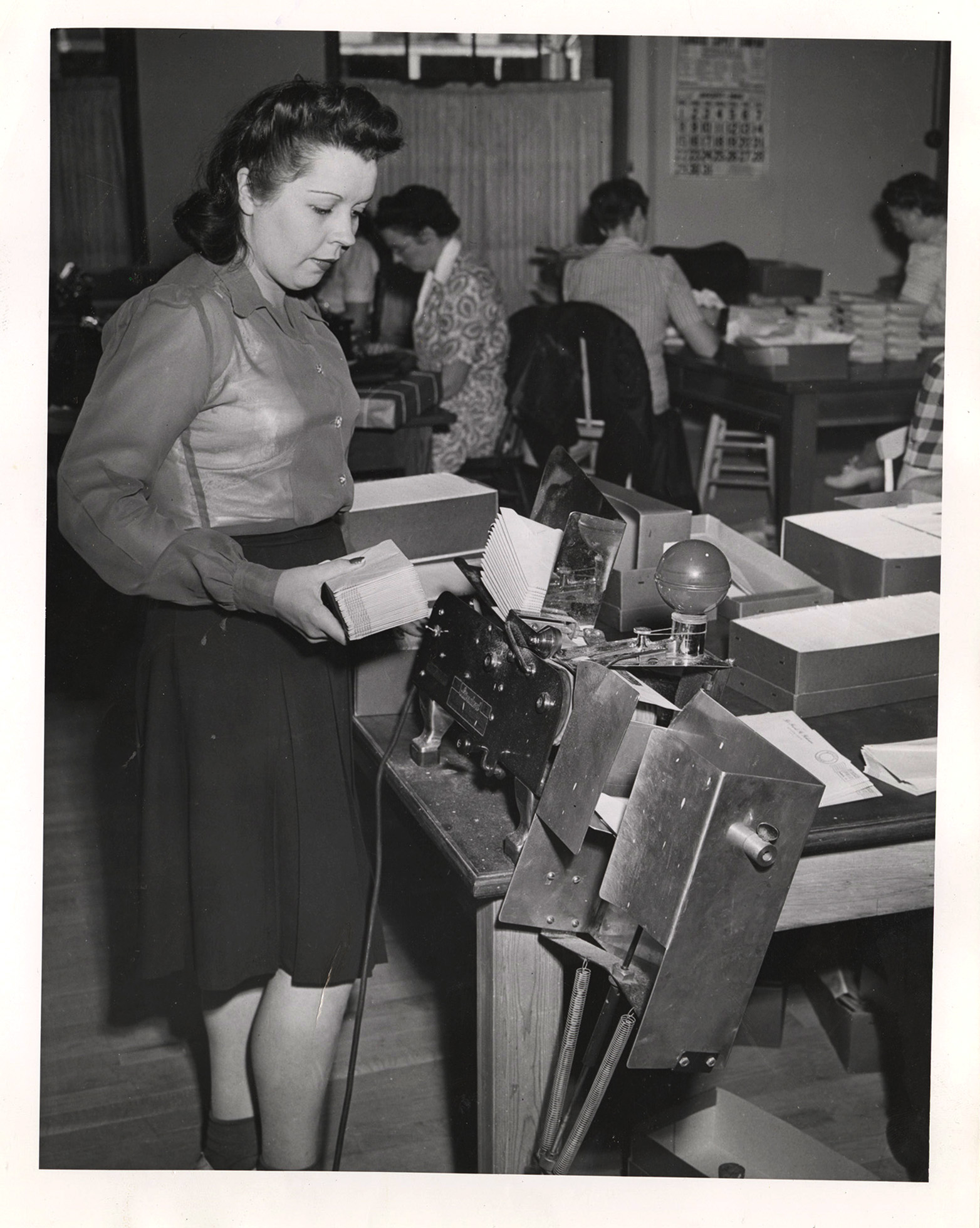 Photograph of unidentified woman using an envelope sorter